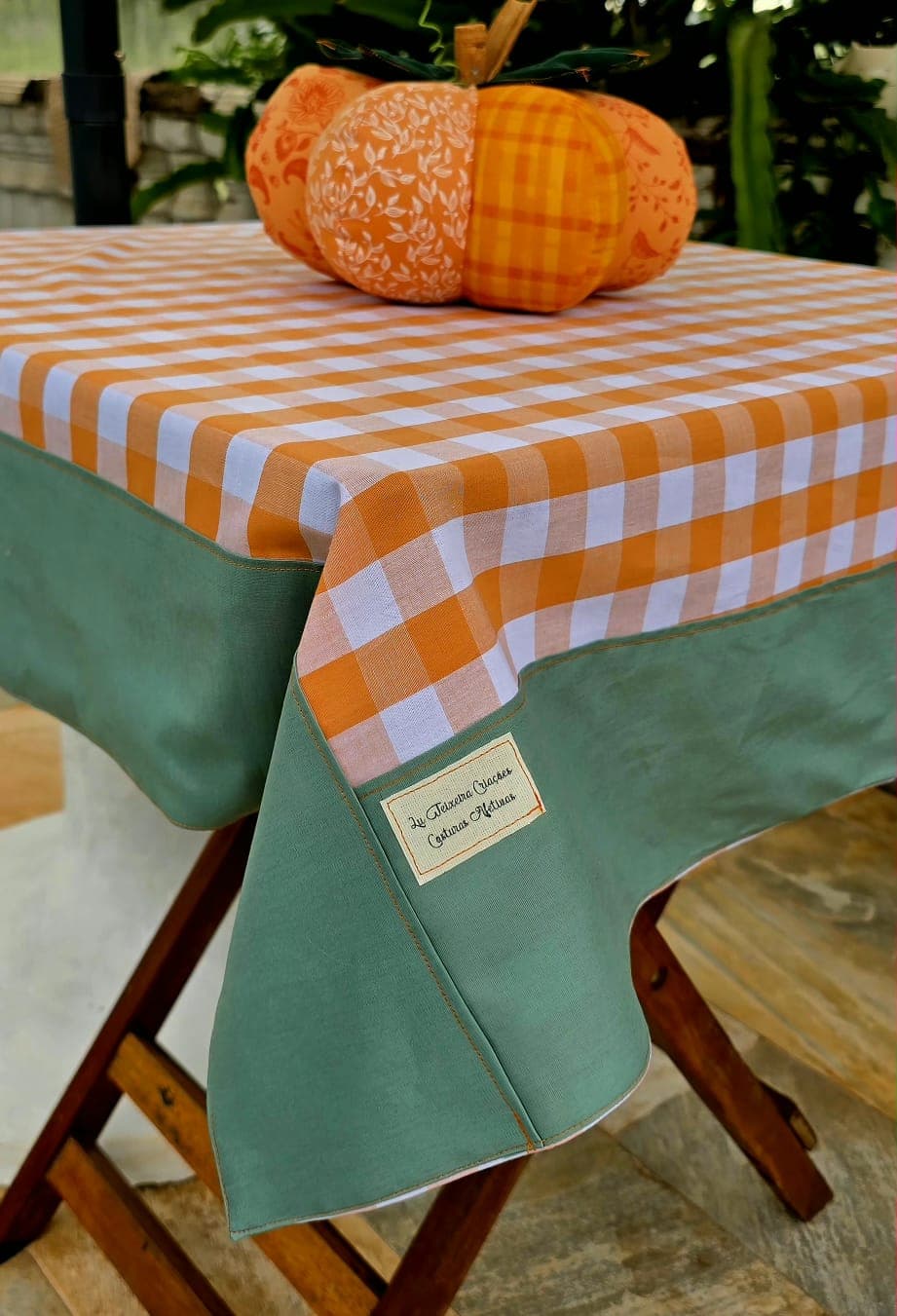 Toalha de mesa xadrez laranja com barrado verde e abóbora decorativa